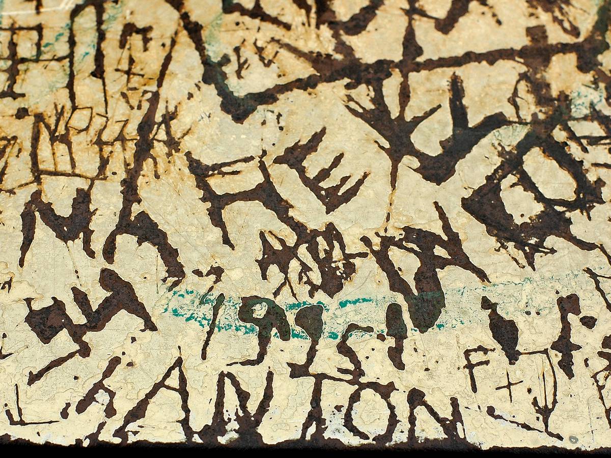 Namen, tekens en boodschappen achtergelaten in stuk roestig metaal