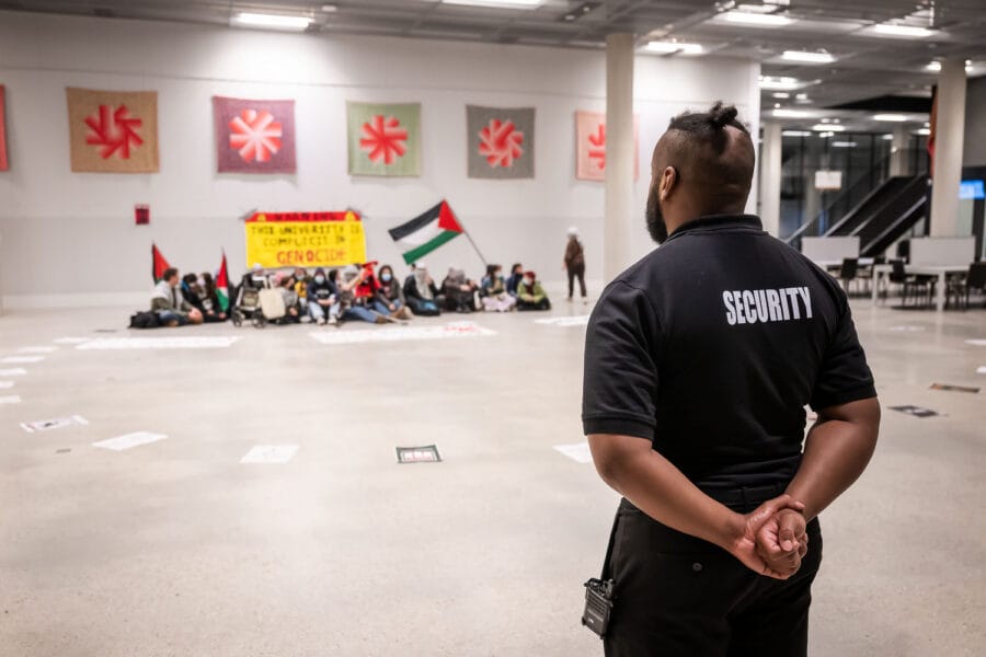 Een beveiliger van Tilburg University kijkt toe