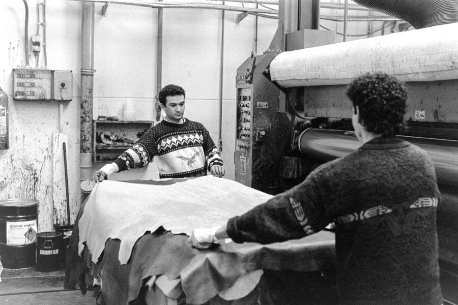 Werknemers bij transportband in leerverwerkingsbedrijf