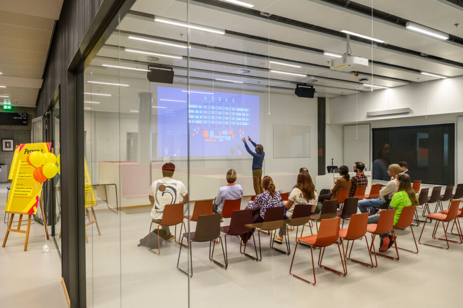 Faces of the Future evenement van Mindlabs Tilburg: Man staat voor bord uitleg te geven aan groep studenten